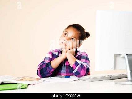 Ragazza seduta e pensando alla sua scrivania Foto Stock