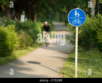 Uomo in bicicletta su un percorso pedonale e ciclabile Foto Stock