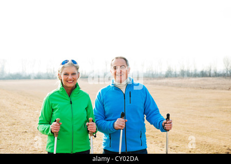 Sorridente coppia senior facendo Nordic walking Foto Stock
