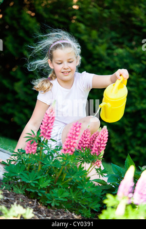 Ragazza con un annaffiatoio in giardino Foto Stock