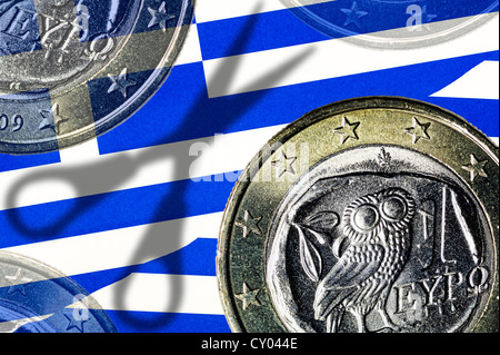 Greco delle monete in euro e l'ombra di un paio di forbici su una bandiera greca, immagine simbolica per debito tagli per la Grecia Foto Stock