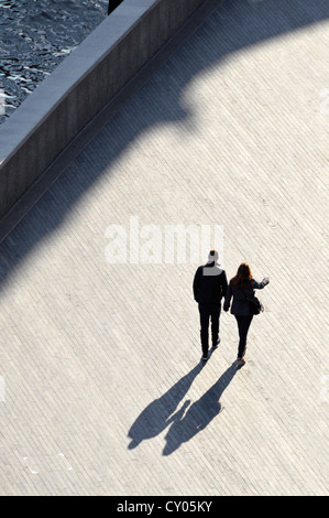 Vista aerea silhouette coppia che cammina mano nella mano accanto al fiume Tamigi lungo la passeggiata lungo il fiume possibile immagine di copertina del libro Southwark Londra Inghilterra Regno Unito Foto Stock