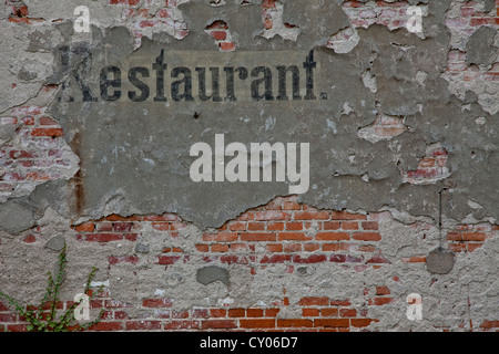 Il vecchio segno pubblicità 'restaurant' sulla facciata di una casa diroccata, Templin, Brandenburg Foto Stock