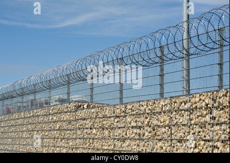 Barriera antirumore e recinzione di sicurezza con filo spinato di fronte al piazzale di stoccaggio di un edificio centrale, Eckental, Media Franconia Foto Stock