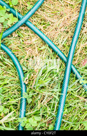 Tubo flessibile in plastica giacente sul terreno di un cortile Foto Stock