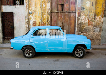 Vecchia auto di fronte a una vecchia casa in Havana. Una attrazione turistica di per sé, un gran numero di auto d'epoca sono ancora in uso Foto Stock