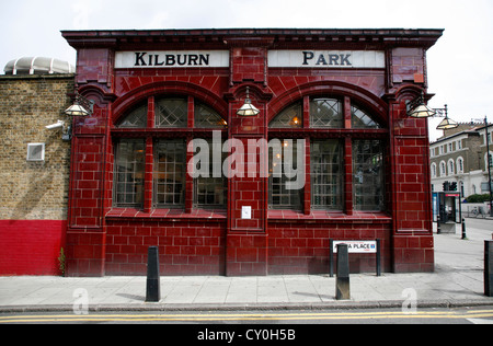 Oxblood piastrellate facciata per la fermata della metropolitana Kilburn Park, Kilburn, London, Regno Unito Foto Stock