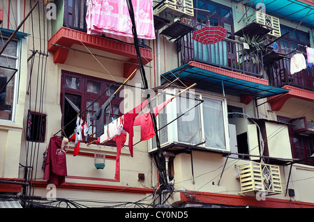 Casa con biancheria appesa a windows su canne di bambù in una strada di Shanghai - Cina Foto Stock