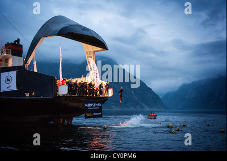 L'inizio di Norseman Xtreme Triathlon 2012 sta per accadere come gli atleti saltare fuori di un traghetto in Hardangerfjorden. Foto Stock