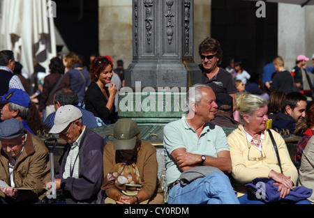 Turisti e residenti godendo il sole in Plaza Mayor, Madrid Foto Stock