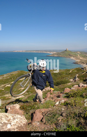Europa Italia Sardegna Provincia di Oristano ciclista conduce a spalla la sua bici, la penisola del Sinis Foto Stock