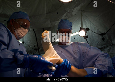 Esercito degli Stati Uniti john major detro, sinistra e 1lt. bryan malone, sia dal 240th in avanti il team chirurgico, Fort Bragg, n.c., applicare un bendaggio esmark per la simulazione di una gamba del paziente in sala operatoria durante un esercizio di campo in corrispondenza della giunzione readiness training center (jrtc), Fort polk, la., oct. 15, 2012. jrtc 13-01 è progettato per preparare ed educare militare degli Stati uniti i membri del servizio per le installazioni per il medio oriente. Foto Stock