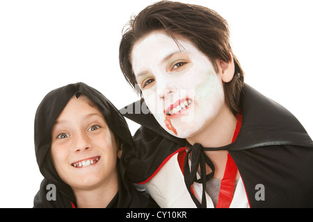 Due fratelli vestiti con i loro costumi di Halloween. Uno è un goblin e gli altri è un vampiro. Sfondo bianco. Foto Stock