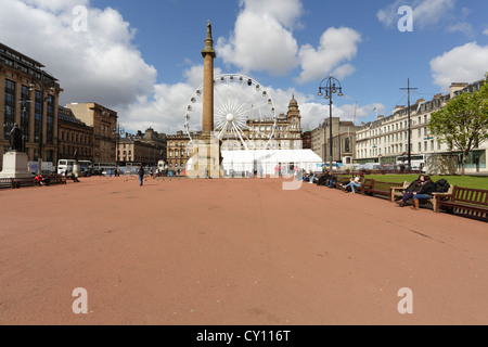 George Square con una temporanea ruota panoramica R40 e una vecchia superficie rossa di asfalto nel centro di Glasgow, Scozia, Regno Unito Foto Stock