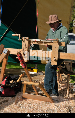 Uomo che dimostra tornio polare, su un tornio tapis roulant, facendo slindles sedia al Autunno Campagna Show, West Sussex, Inghilterra, Regno Unito Foto Stock