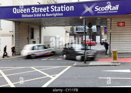 Stazione di Queen Street con taxi e pedoni sfocati in movimento che arrivano e vanno su North Hanover Street nel centro di Glasgow, Scozia, Regno Unito Foto Stock