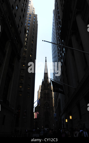 Sfumatura scura " urbano " vicolo ritratto, Broad Street verso la Chiesa della Trinità, sagome di persone a piedi Wall Street, New York Foto Stock