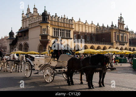 Carrello tradizionale e Cavalli attendere per i turisti di fronte il panno Hall il 27 ottobre 2006 a Cracovia in Polonia. Foto Stock