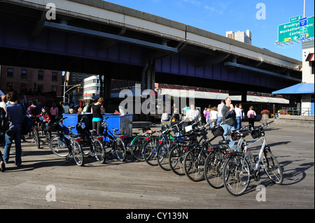 Blue sky view, verso FDR Autostrada, gente che passeggia, "Blazing selle Bike Rentals', Pier 17, South Street Seaport, New York Foto Stock