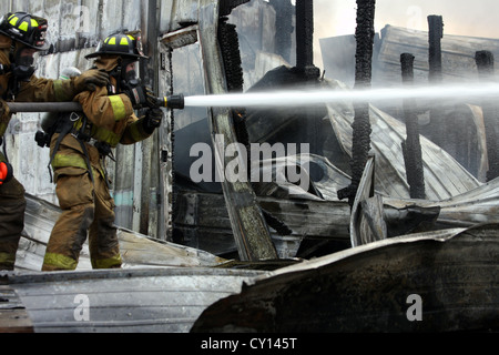 Un team di estinzione mettendo acqua su un incendio in un edificio industriale in Wisconsin Foto Stock