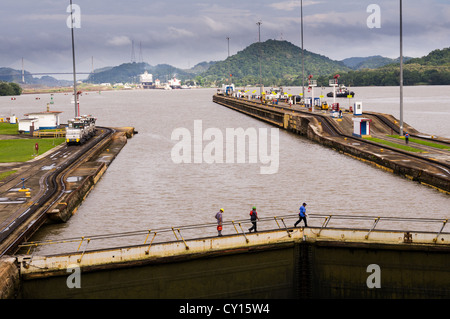 Panama Panama Canal tre lavoratori attraversare i cancelli chiusi del Miraflores Locks sul Canale di Panama Foto Stock