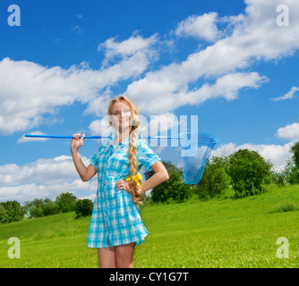 Bella ragazza con butterfly net in piedi sul prato verde Foto Stock