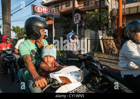 Bambino su un ciclomotore in Legian la strada principale di Legian, meridionale di Bali, Indonesia. Foto Stock