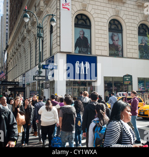 Orde di acquirenti in Herald Square a New York pass un gap flagship store Foto Stock