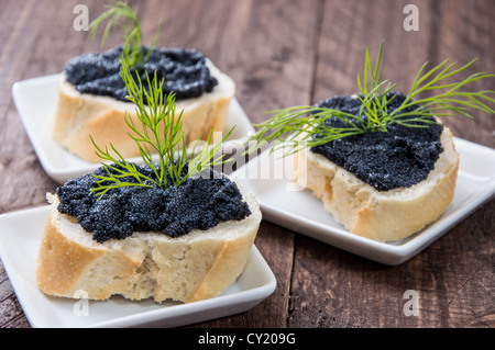 Baguette con caviale su sfondo di legno Foto Stock