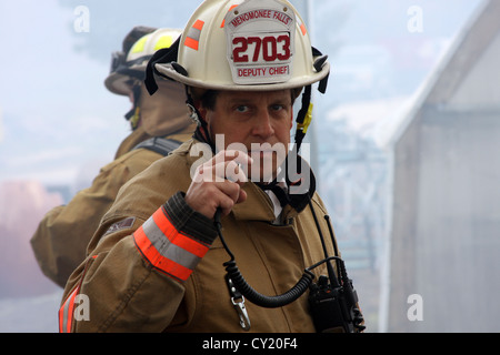 Menomonee Falls Fire Vice Capo di parlare alla radio a una scena di fuoco Foto Stock