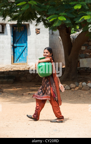 Rurale villaggio indiano ragazza raccolta di acqua da un comune serbatoio di acqua. Andhra Pradesh, India Foto Stock