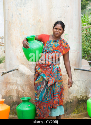 Rurale villaggio indiano donna raccolta di acqua da un comune serbatoio di acqua. Andhra Pradesh, India Foto Stock