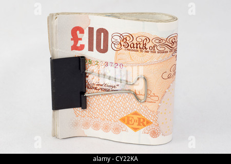 Un fascio di dieci British pound note tenute insieme con un bulldog clip Foto Stock