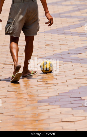 Uomo a giocare il gioco del calcio sul Riverfront Promenade in Phnom Penh Cambogia Foto Stock