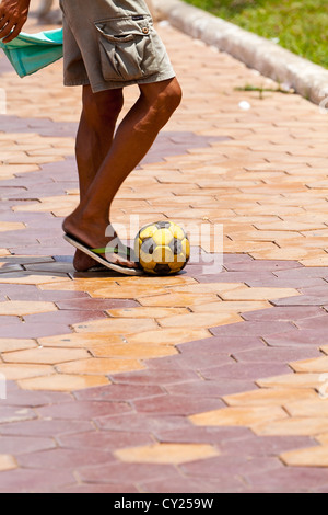 Uomo a giocare il gioco del calcio sul Riverfront Promenade in Phnom Penh Cambogia Foto Stock