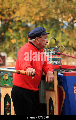 Uomo anziano al timone di un British canal narrowboat. Foto Stock