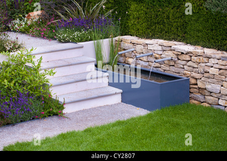 Vista del giardino contemporaneo con il trogolo di acqua e fontana. Foto Stock