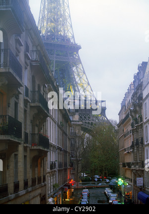 Strada che conduce alla Torre Eiffel a Parigi con le auto parcheggiate al di sotto di edifici di appartamenti Foto Stock