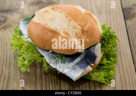 Aringa fresca su un rullo contro lo sfondo di legno Foto Stock