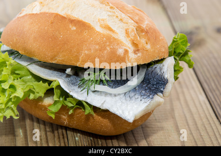 Aringa fresca su un rullo contro lo sfondo di legno Foto Stock