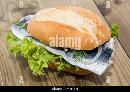 Aringa fresca su un rullo contro lo sfondo di legno Foto Stock
