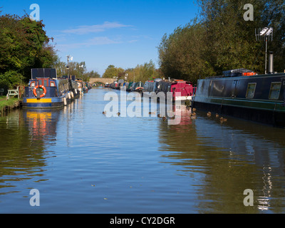 Narrowboats ormeggiata su entrambi i lati della Oxford Union Canal a Heyford Wharf, Oxfordshire Foto Stock