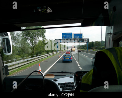 Una vista del traffico sull'autostrada M4 e segni da dentro un autobus National Express Inghilterra REGNO UNITO Foto Stock