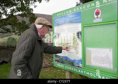 L'uomo la lettura di un Parco Nazionale di Brecon Beacons information board a Llanthony South Wales tourist info avviso Foto Stock