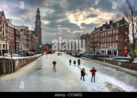 Persone skate su Amsterdam i canali congelati in una sera d'inverno Foto Stock