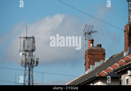 Un telefono cellulare montante situato accanto all'antenna TV a stretta vicinanza, che mostrano il potenziale di interferenza della televisione Foto Stock