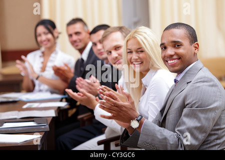 Multi etnico gruppo business vi saluta con battimani e sorridente Foto Stock