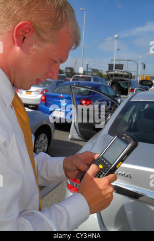 Boston Massachusetts,Logan International Airport,BOS,Alamo Car Rental,uomo uomini maschio adulti,dipendenti lavoratori dipendenti lavoratori dipendenti personale di lavoro,agente,utilizzando la mano Foto Stock