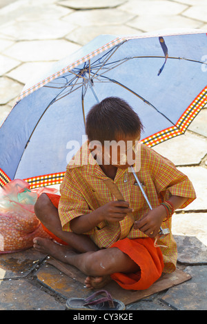 Ragazzino con tradizionale crema Thanaka sul suo volto a Rangoon, Myanmar Foto Stock