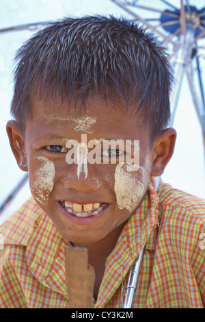 Ragazzino con tradizionale crema Thanaka sul suo volto a Rangoon, Myanmar Foto Stock